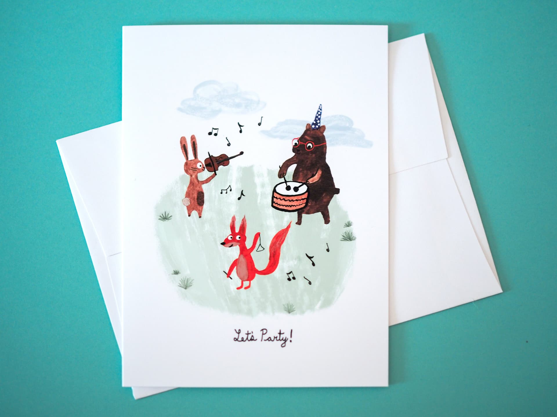 A greeting card with an illustration of an animal band with a rabbit, bear, and fox playing music. The text on the card reads 'Let's Party!'.
